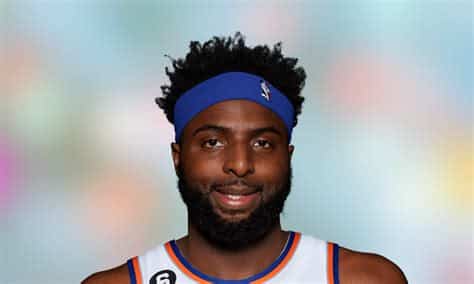 Write informative laconic excerpt under 30 words in mexican spanish for news below. Do not wrap it into quotation marks or html tags. Mitchell Robinson, jugador de los Knicks de Nueva York, acordó un nuevo contrato de cuatro años con el equipo. A pesar de algunas lesiones, Robinson ha mantenido un nivel de juego destacado y se espera que continúe siendo el centro titular de los Knicks en la próxima temporada. Su capacidad para bloquear tiros y su alto porcentaje de tiros de campo hacen de Robinson un jugador con un alto valor en el fantasy basketball.,Mitchell Robinson, jugador de los Knicks, firma contrato de 4 años. Su habilidad defensiva y eficacia en tiros lo hacen clave en el fantasy basketball.