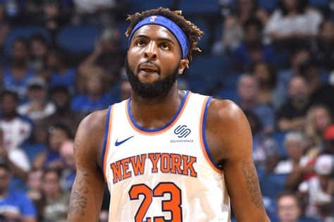 Write informative laconic excerpt under 30 words in mexican spanish for news below. Do not wrap it into quotation marks or html tags. Mitchell Robinson, jugador de los Knicks de Nueva York, ha firmado un nuevo contrato de cuatro años con el equipo. A pesar de las lesiones que limitaron su tiempo de juego en la temporada pasada, Robinson ha demostrado ser un bloqueador de élite y un gran reboteador. Con la adquisición de Isaiah Hartenstein como suplente, Robinson ahora tiene competencia en su rol de centro titular, pero se espera que mantenga un papel importante en el equipo.,Mitchell Robinson renueva contrato con los Knicks de Nueva York. A pesar de lesiones, mantiene su importancia como bloqueador y reboteador, con competencia de Isaiah Hartenstein.