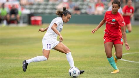 Write informative laconic excerpt under 30 words in mexican spanish for news below. Do not wrap it into quotation marks or html tags. Marta scored on a second-half penalty kick for the Orlando Pride, who didn&apos;t flinch despite playing the second half a player down and beat the host Kansas City Current 2-1 on Saturday in a matchup of unbeaten teams.The Pride improved to 11-0-5, including 5-0-3 in road matches. Kansas City dropped to 10-1-5.Barbra Banda had the first Orlando goal in the 37th minute. Banda has 12 goals in 12 matches this season, including at least one in three straight matches. Marta posted her fifth goal of the season.A bad foul on Kansas City goalie Adrianna Franch in the penalty area allowed for Marta&apos;s penalty kick in the 63rd minute.Marta (center) celebrates with Orlando teammates Barbra Banda (left) and Adriana.Nick Tre. Smith-USA TODAY SportsCarrie Lawrence&apos;s red card late in the first half put the Pride in a tough situation. Orlando Goalkeeper Anna Moorhouse made seven saves.Kansas City had six shot attempts in extra time, with Moorhouse notching two saves during that span.Temwa Chawinga scored for Kansas City in the 39th minute, extending her streak of goals to five consecutive matches. She has scored seven of her 12 goals this season during that stretch.,En un emocionante partido, Orlando Pride venció 2-1 a Kansas City Current, con goles de Marta y Barbra Banda. Impressively, Pride mantiene récord invicto.