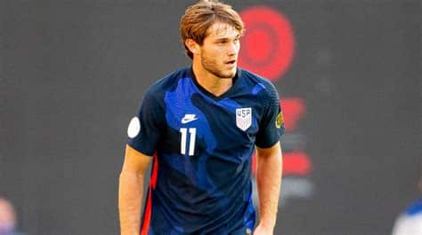 Write informative laconic excerpt under 30 words in mexican spanish for news below. Do not wrap it into quotation marks or html tags. Tanner Tessmann has made two appearances for the USMNT, his debut coming in January 2021. Daniela Porcelli/ISI Photos/Getty ImagesUnited States midfielder Tanner Tessmann is set to sign for Lyon after the club agreed a deal with Venezia that includes a €7 million ($7.8m) transfer fee, a source has told ESPN.Tessmann is expected to undergo a medical at the French club later on Saturday ahead of signing a five-year contract, the ESPN source said.The 22-year-old, who has one year left on his contract at Venezia, had already agreed personal terms with Lyon, owned by American billionaire John Textor.The signing comes despite the club having assured Ligue 1&apos;s financial authority that they would accumulate €100 million ($111m) in sales this summer in order to avoid any further restrictions from the league&apos;s financial watchdog.Tessmann made 20 Serie A appearances for Venezia before their relegation to Serie B at the end of the 2021-22 season. He was a key contributor as the club were promoted back to Italy&apos;s top division last season, missing just one game while contributing seven goals and three assists.He has made two appearances for the senior U.S. men&apos;s national team, making his debut in January 2021. ,El mediocampista de 22 años Tanner Tessmann fichará por Lyon, tras acuerdo con Venezia. Firmará contrato de 5 años, tras transferencia de €7 millones.