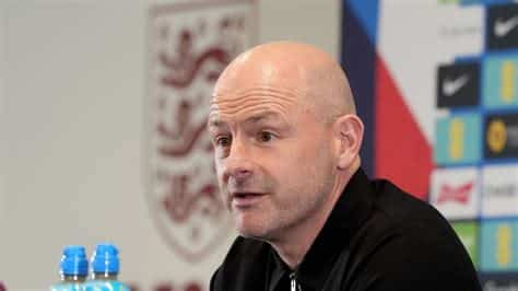 Write informative laconic excerpt under 30 words in mexican spanish for news below. Do not wrap it into quotation marks or html tags. playWhat Lee Carsley needs to succeed with England squad (1:54)James Olley, Mark Ogden and Rob Dawson discuss what Lee Carsley brings to England as interim manager and how he can find success ahead of the Nations League. (1:54)England interim head coach Lee Carsley has described himself as a "safe pair of hands" and refused to be drawn on whether he wanted the role on a permanent basis after announcing his first squad on Thursday.The 50-year-old has assumed a caretaker role following Gareth Southgate&apos;s decision to step down after losing the Euro 2024 final to Spain in July.Carsley, who began working with the Football Association (FA) in 2015 and steps up from his position as under-21 boss, will be in charge for four matches across September and October, starting with next month&apos;s UEFA Nations League double-header against the Republic of Ireland and Finland.Asked how he found out he would be offered the temporary position, Carsley said: "Gareth had made his decision and it was probably a couple of days later when myself and [FA technical director] John McDermott had a conversation, very informal."We speak most days anyway, [this time] basically about what my thoughts were, I suppose if it was something I was not willing to do, but capable of, because it is a big responsibility."The fact I&apos;ve worked with so many players, I understand an international camp, I understand selection. I probably see myself as maybe a safe pair of hands at the minute. It was a really easy decision, a really proud moment."I&apos;ve always said all along I feel really supported and trusted, not only by John but the rest of the people on the board have made me feel so supportive, I don&apos;t feel like its me and my decision. I feel like I&apos;ve got a really strong team of staff behind me that are part of this little period."Lee Carsley will take charge of the next four England matches. Joe Giddens/PA Images via Getty ImagesThe FA are drawing up a list of possible candidates, which includes Newcastle boss Eddie Howe and former Chelsea manager Graham Potter, but have refused to confirm whether interviews have yet taken place.Pushed on whether he would take the job if it was offered to him tomorrow, Carsley replied: "It&apos;s probably important I see how the games go! The priority for me... I know it is probably a boring answer but the best person is going to get the job, the best person deserves to do this job. There are some brilliant coaches out there, some excellent head coaches and I trust the people involved in the process that they will get the best person."I&apos;ve not really thought too much about it if I&apos;m being honest. I&apos;ve learned in the past when I was caretaker manager at Brentford, Coventry, Birmingham City, I spent so much energy talking about why I didn&apos;t want the job that you forget to do the job."Maybe because I&apos;m 50 now, I&apos;m a bit more relaxed and comfortable in my skin. I&apos;m happy to help out, happy to do the best job that I can and we&apos;ll see what happens in the future."Carsley revealed he spoke with Southgate -- who managed England at four tournaments -- prior to his appointment being made public."I spoke to him after [I took the job], probably just before it was going to come out. I wanted him to know what was happening before it actually broke. That was important for me. I&apos;ve got so much respect for Gareth and Steve [Holland], the way they made my job and made me feel, the help and support they gave so it was important I spoke to them."It has been a really hectic couple of weeks to try and get my head around the magnitude of the job, getting around to as many games as I can, trying to see as many players as I can."I&apos;ve been lucky in the past in that I&apos;ve done this before in taking over from a short-term point of view at club level."Generally you go to a club where things aren&apos;t going very well but obviously this is the opposite. I think it is fair to say the job that Gareth and Steve did and the position I&apos;m picking up the squad in is totally different to what they inherited."The expectation around the squad and the players is pretty exciting. I understand that I am in a really privileged position." ,Lee Carsley, entrenador interino de Inglaterra, reemplaza a Gareth Southgate tras la Euro 2024. Dirigirá 4 partidos, comenzando con la Liga de Naciones de la UEFA.