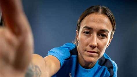 Write informative laconic excerpt under 30 words in mexican spanish for news below. Do not wrap it into quotation marks or html tags. playLucy Bronze desperate to repeat UWCL success at Chelsea (1:03)Lucy Bronze shares her motivations for joining Chelsea after winning the women&apos;s Champions League at Barcelona. (1:03)Aug 13, 2024, 10:00 AM ETCOBHAM, England -- Despite the sweltering heat at Chelsea&apos;s training ground on the U.K.&apos;s hottest day of the year so far, new signing Lucy Bronze is not fazed. Having spent the past two seasons basking in the Spanish sunshine in Barcelona, the England defender used to the heat. But being back in the Women&apos;s Super League (WSL) for the first time since she left Manchester City in 2022 means something else is on her mind."It&apos;s the cold that worries me," she tells ESPN. "It&apos;s been a good first week; the temperature has been nice."It is the first time that the 32-year-old has spoken to non-club media since making a free transfer to the WSL champions in the wake of Emma Hayes&apos; exit this summer, but you wouldn&apos;t guess it. Bronze&apos;s easy-going demeanour would make anyone think she had been around the team for months, not just a week. But that describes her character."Although I&apos;m new, and a bit of an older player, a lot more experienced, I want to learn the new things and the way that we work here," she says. "But then there&apos;s a new manager [Sonia Bompastor] as well, so there are different things going on, which nobody&apos;s 100% sure of."Some players describe a move to a new club as like the first day of high school: a sense of familiarity but a brand-new challenge. For Bronze, surrounded by plenty of her England international teammates, there are no nerves; this is the least nervous she has been at any of her seven clubs in her 17-year career to date."I think your first impression matters a lot," she says. "So you&apos;re making sure you&apos;re on time for everything; you&apos;ve got everything you&apos;re supposed to have. This is probably the least nervous I&apos;ve been in moving to a new club and a new place. Having signed for a team in France [Lyon] and Spain [Barcelona], not knowing the language and not knowing who even speaks the same language as you is definitely more nerve-wracking. So having experiences like that makes this one a lot calmer and a little bit easier."Having won everything domestically in England during her previous spells with Liverpool, Everton, Sunderland and City, she has collected on-pitch accolades like they are Pokémon cards during her career to date -- five Champions League titles, three English and French titles, two Spanish, 10 assorted domestic cups, and five trophies with England, including the European Championship in 2022.But she is also a polyglot, adept in several languages including French, Spanish and Portuguese. The former comes from her time at Lyon, where she played alongside Chelsea&apos;s new assistant coach, Camille Abily, while Bompastor was coach of the academy setup at the same time. And that will come in handy when it comes to helping Chelsea&apos;s new foreign signings settle in."I think it&apos;s always important to be able to communicate with people in different ways," she says. "I know how much of a difference it makes because you start a preseason, your body hurts, and then your head&apos;s going crazy because you&apos;ve got these languages that you try to keep up with and you want to impress the manager. So it&apos;s nice if I can just explain a little bit in French or Spanish and help out a little bit."Lucy Bronze has won five UWCL titles during her career but wants to bring one to England now. Darren Walsh/Chelsea FC via Getty ImagesBronze has always taken on the role of a "big sister," someone for her teammates to look up to and rely on. It is something she enjoys and comes naturally to her. Possessing an infectious personality, she has bonded with younger members of the England squad, including new Chelsea teammates Lauren James and Aggie Beever-Jones. And despite being a new signing herself, she has taken it upon herself to ensure the other new faces feel welcomed at the club she will call home for the next two years."I&apos;ve been in that position before and wondered &apos;how can I make it easier?&apos;" she says. "Because at the end of the day, if I can make someone&apos;s life a little bit easier and help them a little bit, that&apos;s going to make them a better player, train better, which makes me better and makes the team better. I like seeing the younger players or less-experienced players flourish."For those closest to Bronze, the kindness she has shown toward younger and newer players makes her stands out. "Lucy has an incredible role in our team as a leader," England manager Sarina Weigman said of the defender, who has captained her country on numerous occasions, in October 2022. "Even when not wearing the armband, she is still a leader."And she was integral in helping a 22-year-old James settle into the England setup ahead of the 2023 World Cup. The pair formed a strong bond that developed into a seamless link-up on the pitch, which Chelsea will be hoping to capitalise on at club level now."I think she just knows that I know she is always there if I need the help or if I&apos;ve got any questions, and I think she&apos;s easy to go to," James told Lionesses Down Under in August 2023. "It&apos;s strange because we get on so well, but we&apos;re like 10, 11 years apart."Lucy Bronze&apos;s partnership with Chelsea forward Lauren James will be key for club and country. Chris Lee - Chelsea FC/Chelsea FC via Getty ImagesAt the end of this week, Chelsea fly to North America to continue their preseason preparations in Bompastor&apos;s first game in charge of the club against NWSL side NY/NJ Gotham on Aug. 19, before taking on Arsenal at Audi Field in Washington DC on Aug. 25. The U.S. is not unfamiliar territory for Bronze, who began her career at college in North Carolina, and she is impressed by how much the women&apos;s game has grown in recent years."It&apos;s really exciting because Chelsea vs. Arsenal is a game we could play 20 minutes away," she laughs. "But that&apos;s the exciting thing: that the game has grown all around the world. Meeting so many of the fans that we have abroad, it&apos;s amazing that they get to see us play there and that we get to see them as well."Preseason tours are something that have been quite big in the men&apos;s game for a long time. So it&apos;s nice that we can grow that and grow our fan bases. It&apos;s something that means a lot to us in the women&apos;s game, making sure that we can connect with all the fans from all over the world."For players as well ... the faster you get to know each other, both on and off the pitch, the better -- and going away in preseason is the best way to do that. You learn a lot about each other. So it&apos;s a good way to kind of fast forward that process of team bonding."The growth of the women&apos;s game in England has skyrocketed since England&apos;s victory at Euro 2022 but, playing in Spain at the time, Bronze missed out seeing the increase in profile and fans firsthand. So when the opportunity to play in the WSL again came up, she jumped at the chance."I really am excited to play in front of the fans," she says. "I&apos;ve not witnessed how women&apos;s football has changed [in England], which is obviously something that I was a part of, so I&apos;m excited for that."I love the fans in Spain and France, but it&apos;ll be so nice to be able to see all the England fans who have supported us as the Lionesses to then put on a Chelsea shirt and come to Stanford Bridge and all the away games as well. That connection is something I&apos;m really looking forward to." ,Lucy Bronze regresa a la Women's Super League con el Chelsea, enfocada en lograr más éxito tras ganar la Champions League con el Barcelona.