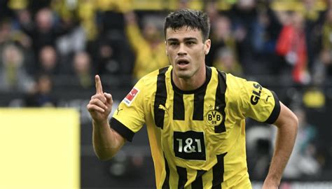 Write informative laconic excerpt under 30 words in mexican spanish for news below. Do not wrap it into quotation marks or html tags. playWhy Gio Reyna is in a &apos;toxic relationship&apos; with Dortmund (1:51)Herculez Gomez and Sebastian Salazar discuss Gio Reyna&apos;s situation at Borussia Dortmund, with the USMNT player now staying at the club for another season in the Bundesliga. (1:51)Gio Reyna is stuck.As the summer transfer window closed last week in the major European leagues, some players celebrated the completion of getting new deals. Others felt the disappointment of remaining in suboptimal playing situations. Reyna, the Borussia Dortmund and USMNT midfielder, is definitely anchored in the latter category.That Reyna needs to find a way to get on the pitch is clear. Where that can happen isn&apos;t as obvious. Last season, he logged a total of just 329 minutes in 13 league and cup appearances. That included his loan spell at Premier League side Nottingham Forest, which didn&apos;t go anywhere near like he wanted, as he found himself mostly on the bench as Forest battled to avoid relegation.Reyna then returned to Dortmund, where new manager Nuri Şahin was waiting for him. There was hope that a different coach would arrive at a different conclusion as to how much Reyna could help, but there&apos;s been little change in fortune. Reyna has made just a solitary league appearance this season for a total of nine minutes so far.Yet Dortmund are keen to hold onto Reyna. There will be UEFA Champions League games to test the depth of Die Schwarzgelben, which would seemingly point to more playing opportunities for the U.S. international than he received last year. Reyna certainly appears to be a player realizing he needs to do everything he can to force his way into the lineup.His efforts have been noticed by the Dortmund brass."He worked on himself, worked on his stability, worked on his charisma," Dortmund sporting director Sebastian Kehl told Bild. "This clever turning between the lines and his goal threat -- he has developed that further. Gio can still be very important for us this season."That Dortmund want to hang on to Reyna, at least for the time being, is understandable. They&apos;ve invested a lot in the player over the years and showed patience in terms of his numerous injuries, hoping that he would come good. There is a natural reluctance to cut loose a talented, skillful player who might end up shining elsewhere. It also speaks well of Reyna&apos;s mentality that he wants to fight his way back into the Dortmund lineup. If he can achieve a breakthrough, he might yet take the long-awaited next step in his career.That said, can Reyna achieve that when he&apos;s consigned to bit-part status? That&apos;s unlikely, and a strong argument can be made that such a role will see Reyna&apos;s game stagnate further. He needs to find a better situation."I think he needs to go to a club that&apos;s building around him, where he is the man," said former U.S. men&apos;s national team assistant Luchi Gonzalez, who coached Reyna during the last World Cup cycle."I don&apos;t know if that&apos;s in Germany. I don&apos;t know if that&apos;s in the Netherlands. I don&apos;t know if that&apos;s in Belgium. I don&apos;t know if that&apos;s in Spain. But I know there are plenty of teams out there that would love to build around him and have him be the man for them. I&apos;m excited to see that develop with time. And I think once he does that, then little by little, he can maybe go back to a similar club like Dortmund or a similar level club and then dominate."Gio Reyna has only logged nine minutes for Borussia Dortmund this season under new manager Nuri Şahin. (Photo by Alex Gottschalk/DeFodi Images via Getty Images)There are plenty of examples of players who have done just that and then excelled. Mohamed Salah never was able to break through at Chelsea, but he rebuilt his confidence in Italy with Fiorentina and AS Roma, and then later returned to the Premier League with Liverpool and became a club legend.The same was true for Kevin De Bruyne, who after his own struggles at Chelsea parleyed a stellar season with Bundesliga side Wolfsburg to later become the attacking hub of Pep Guardiola&apos;s Manchester City sides. Closer to USMNT circles, Luca de la Torre dropped down from Fulham in the Premier League to Heracles Almelo in the Eredivisie and showed enough quality to move to LaLiga with Celta Vigo where he garnered considerable playing time the past two seasons (though of late he&apos;s struggled for minutes).Reyna himself is showing more of a willingness to make such a move. He still feels the sting of the Forest adventure and realized the bright lights of the Premier League didn&apos;t provide what he needed. A more practical move to the likes of Marseille or Sevilla -- both of which were reportedly on the table -- would have been better for his career. Bild reported on Tuesday that VfL Bochum inquired about a possible loan move earlier this summer, one that Reyna welcomed, only for Dortmund to scuttle the deal by demanding a full transfer instead.Gonzalez added that he&apos;s seen enough growth in Reyna&apos;s game that he could excel as a team&apos;s attacking centerpiece. He&apos;s improved on the defensive side of the ball as well."I just see more balance in his game," he said.Herculez Gomez and Sebastian Salazar debate the biggest storylines and break down the best highlights that soccer in the Americas has to offer. Stream on ESPN+ (U.S. only) "I see him really kind of taking the reins when he wants to. When he&apos;s in the attacking third or the attacking half, you can see he creates combination plays. He makes final passes. He drives at defenders. He&apos;s doing that, I think, with better balance and awareness and decision-making and better responsibility."You see him working his butt off defensively. Whether he&apos;s central, whether he is wide. I saw him defending in the box his last few games with the national team and doing it with a lot of focus and understanding that&apos;s what the team needs to, to win, and you see a player that&apos;s becoming more and more complete."Continuing that evolution requires getting on the field. The next three months will reveal whether that can happen with enough regularity in Dortmund. Otherwise, he&apos;ll need to find a new situation when the European transfer window reopens in January. The hope is then he can get unstuck. ,El mediocampista Gio Reyna enfrenta un dilema en Borussia Dortmund, con escasas oportunidades de juego y la necesidad de encontrar un nuevo rumbo en su carrera.