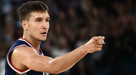 Write informative laconic excerpt under 30 words in mexican spanish for news below. Do not wrap it into quotation marks or html tags. Bogdan Bogdanovic, jugador de baloncesto serbio, ha tenido una carrera inconsistente y ha tenido dificultades para mantener un papel constante en su equipo. A pesar de tener momentos destacados y promedios sólidos en algunas temporadas, Bogdanovic ha lidiado con lesiones y ha tenido que competir por minutos y oportunidades en la rotación del equipo. Su último equipo, los Atlanta Hawks, cuenta con otros jugadores destacados como Trae Young y Dejounte Murray que ocupan la mayoría de los minutos y la posesión del balón, lo que limita el rendimiento de Bogdanovic en términos estadísticos.,El jugador serbio de baloncesto Bogdan Bogdanovic ha enfrentado inconsistencias en su carrera, luchando por un papel estable en los Atlanta Hawks.