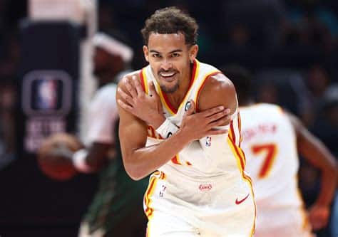 Write informative laconic excerpt under 30 words in mexican spanish for news below. Do not wrap it into quotation marks or html tags. Trae Young, el base estrella de los Atlanta Hawks, registró la octava cantidad más alta de puntos de fantasía en la temporada pasada y promedió 26.2 puntos y 10.2 asistencias por partido. A pesar de la adición de Dejounte Murray al equipo, se espera que Young mantenga sus números de asistencias, ya que Clint Capela sigue siendo su objetivo preferido. La eficiencia de Young ha sido cuestionada debido a su bajo porcentaje de tiros de campo y triples, pero su habilidad en tiros libres ha sido consistente y es una fortaleza para él.,Trae Young, base estrella de Atlanta Hawks, destacó en fantasía con 26.2 puntos y 10.2 asistencias. A pesar de Murray, se espera que mantenga su liderazgo con Capela.