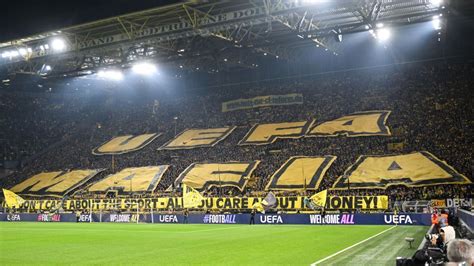 Write informative laconic excerpt under 30 words in mexican spanish for news below. Do not wrap it into quotation marks or html tags. Oct 1, 2024, 04:20 PM ETBorussia Dortmund fans fly a banner ahead of their Champions League game against Cetlic. Getty ImagesBorussia Dortmund fans have made their opposition to Champions League reforms clear with a huge tifo blasting European soccer&apos;s governing body UEFA.The supporters displayed the words "UEFA mafia" behind one of the goals before Tuesday&apos;s match against Scottish team Celtic, above a banner saying "You don&apos;t care about the sport - all you care about is money!" Another banner above showed a website link making clear the banners referred to Champions League reforms.This season UEFA has changed the structure to Europe&apos;s premier competition to add four more teams. The group stage has been scrapped for a league system with each of the now 36 participating teams playing eight opponents once in a first phase of the competition.Also before Tuesday&apos;s game, Celtic fans flew Palestinian and Lebanese flags. ESPN BET is owned and operated by PENN Entertainment, Inc. and its subsidiaries (&apos;PENN&apos;). ESPN BET is available in states where PENN is licensed to offer sports wagering. Must be 21+ to wager. If you or someone you know has a gambling problem and wants help, call 1-800-GAMBLER.Copyright: © 2024 ESPN Enterprises, Inc. All rights reserved. ,Aficionados del Borussia Dortmund protestan contra reformas de la Champions League, acusando a la UEFA de priorizar el dinero sobre el deporte.