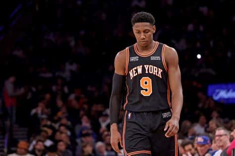 Write informative laconic excerpt under 30 words in mexican spanish for news below. Do not wrap it into quotation marks or html tags. RJ Barrett, jugador de los New York Knicks, ha tenido una carrera volátil pero talentosa hasta ahora. En la temporada 2022-23, Barrett promedió 19.6 puntos, 5.0 rebotes, 2.8 asistencias y 1.7 triples en 34 minutos por partido. A pesar de sus estadísticas contables, Barrett ha tenido problemas de eficiencia en su tiro, con un 43% de acierto de campo y un 31% en tiros de tres puntos.,RJ Barrett, de los New York Knicks, destaca por sus números en la temporada 2022-23, aunque lucha con su eficacia en el tiro.