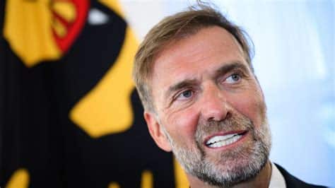 Write informative laconic excerpt under 30 words in mexican spanish for news below. Do not wrap it into quotation marks or html tags. Oct 30, 2024, 06:55 AM ETJürgen Klopp has defended his decision to head up Red Bull&apos;s group of football clubs, saying he "didn&apos;t want to step on anybody&apos;s toes" after his decision prompted a backlash from fans of his former teams in Germany.Klopp is taking over as the drinks company&apos;s head of global football from January in what was widely seen as a surprise move. It will be his first job after leaving Liverpool at the end of last season."I didn&apos;t want to step on anybody&apos;s toes, definitely not, and personally I love all of my ex-clubs," Klopp said in an interview released Wednesday on a podcast hosted by former Real Madrid and Germany midfielder Toni Kroos.Klopp suggested any decision he made to coach another club would also have disappointed some fans."I really don&apos;t know what exactly I could have done for everyone to be happy," he said.Red Bull, and especially its RB Leipzig team, are widely resented by many German football fans, who see the drinks company as an unwelcome corporate presence trying to buy success.Fans at Klopp&apos;s former clubs like Borussia Dortmund have criticized the move, and Mainz fans held up banners this month expressing their disappointment and questioning whether he was "crazy."The German coach spent 18 years at Mainz as a player and coach before joining Dortmund in 2008, where he went on to lead the club to two Bundesliga titles and the Champions League final.Klopp said he had never viewed Red Bull&apos;s involvement in football "so critically," and suggested it played an important role in bringing high-level club football back to the former East Germany with the Leipzig project.Klopp previously said he planned to take a "long break" after leaving Liverpool, where he coached his last game in May after nine years with the club.Yoane Wissa&apos;s close-range finish decided the contest. Bernd von Jutrczenka/picture alliance via Getty Images"I&apos;m 57 so I can still work for a couple more years but I don&apos;t really see myself on the sideline [as a coach] for the time being," he said. "But it was always clear that I wasn&apos;t going to do nothing at all. And then this story with Red Bull came into the picture, and for me it&apos;s outstanding."Klopp said he saw his Red Bull role primarily as an "adviser" working together with coaches at the clubs backed by the drinks giant."I always had the feeling that the coach is very, very often the loneliest person at the club," he said. ,Jürgen Klopp defiende su decisión de liderar los clubes de fútbol de Red Bull, generando controversia entre los fanáticos de sus equipos anteriores en Alemania.