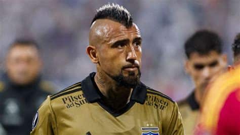 Write informative laconic excerpt under 30 words in mexican spanish for news below. Do not wrap it into quotation marks or html tags. Nov 4, 2024, 04:34 PM ETChilean authorities said Monday they are investigating an alleged sexual assault case involving players at soccer club Colo Colo, including former international Arturo Vidal.A prosecutor&apos;s office in Santiago said the alleged incident took place at a bar in the upscale Vitacura neighborhood in the Chilean capital. It also added that a woman alleged her sister was drugged and sexually attacked by Colo Colo players.A local police officer told journalists that Vidal, 37, was taken to a Vitacura police station, where he went through "an investigative identity check." That is a standard procedure for suspects of crimes.Vidal, who was released after the check, did not comment on the incident.Police also said other players went through similar procedures and have testified about the incident.Also on Monday, a Santiago court released another former Chile international.Jorge Valdivia was arrested on Oct. 22 amid a rape investigation. The 41-year-old Valdiva was accused of raping a woman two days before.Valdivia denied any wrongdoing. ,Autoridades chilenas investigan presunta agresión sexual en club Colo Colo, incluido exinternacional Arturo Vidal. Otro exjugador, Jorge Valdivia, fue liberado en nueva pesquisa por violación.