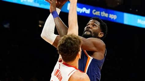 Write informative laconic excerpt under 30 words in mexican spanish for news below. Do not wrap it into quotation marks or html tags. Deandre Ayton tuvo una temporada sólida en 2022-23, promediando 18.0 puntos y 10.0 rebotes por juego. Ayton estableció nuevos récords personales en tiros libres, promediando 3.0 intentos y 2.3 conversiones por juego. A pesar de su desempeño, Ayton fue cambiado a los Trail Blazers en un intercambio que trajo a Damian Lillard a Milwaukee.,Deandre Ayton promedió 18.0 puntos y 10.0 rebotes en la temporada 2022-23. Fue enviado a los Trail Blazers en un cambio por Damian Lillard.