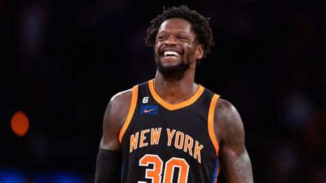 Write informative laconic excerpt under 30 words in mexican spanish for news below. Do not wrap it into quotation marks or html tags. Julius Randle tuvo una sólida temporada en 2022-23, promediando 25.1 puntos, 10.0 rebotes, 4.1 asistencias y 2.8 triples por juego. Randle enfrenta limitaciones en su juego defensivo y su eficiencia en el tiro, lo que limita su valor en el fantasy y su impacto en los playoffs. Los Knicks han mejorado como equipo, pero Randle no es una opción emocionante en el fantasy y se espera que sea seleccionado en rondas medias o incluso bajas en los drafts.,Julius Randle destacó con los Knicks en la temporada 2022-23, pero sus limitaciones defensivas y en tiro restrigen su valor en el fantasy y en los playoffs.